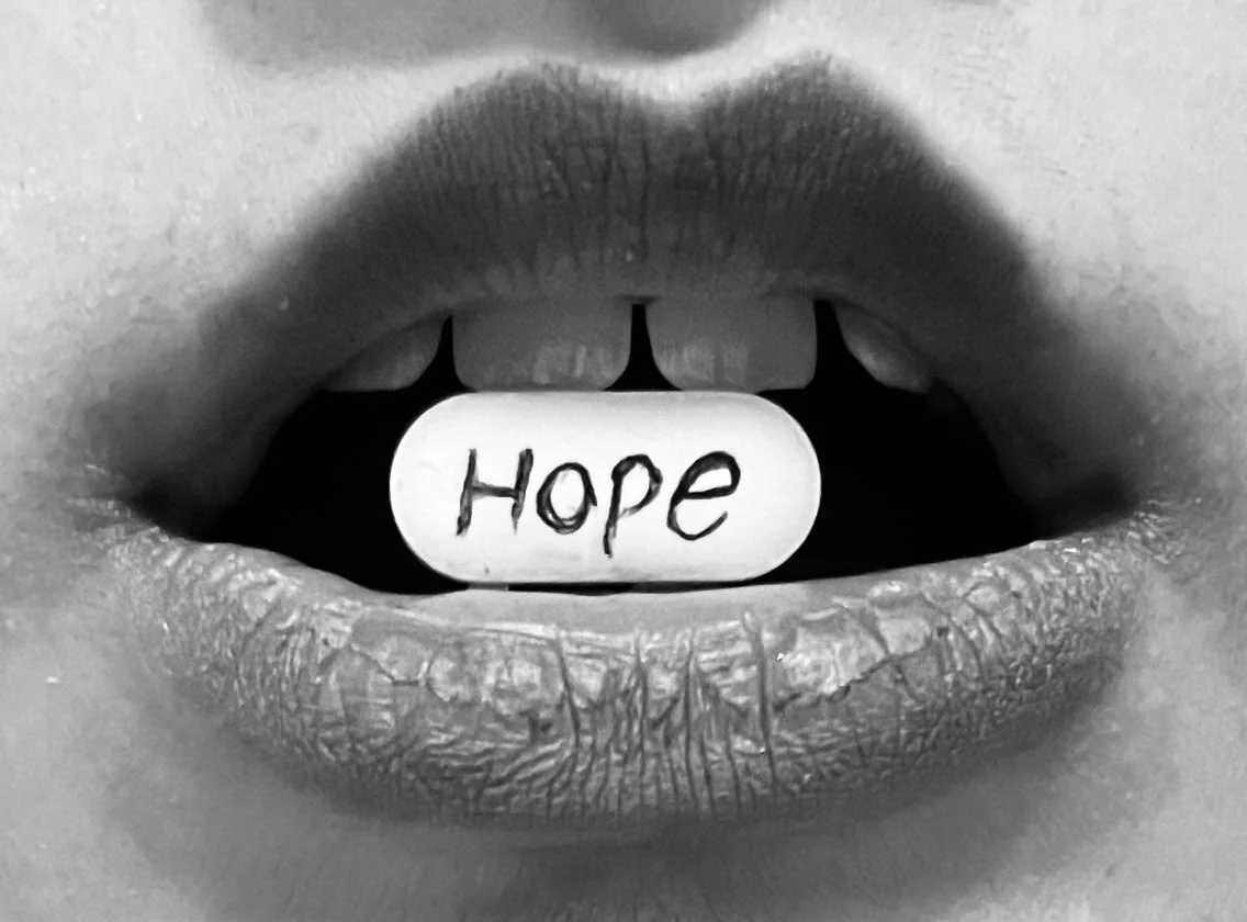 Pastilla con la palabra Hope sostenida entre los labios, representando la búsqueda de nuevas alternativas terapéuticas para la depresión resistente al tratamiento